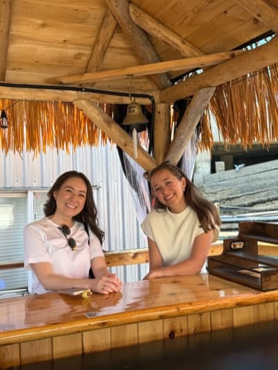 Two Durable teammates leaning on the bar of a waterfront cabana