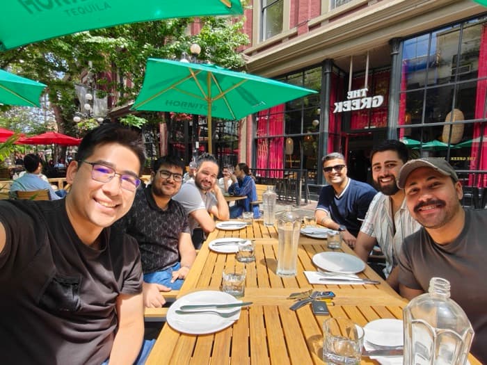 Durable teammates sharing a long lunch table on a restaurant patio