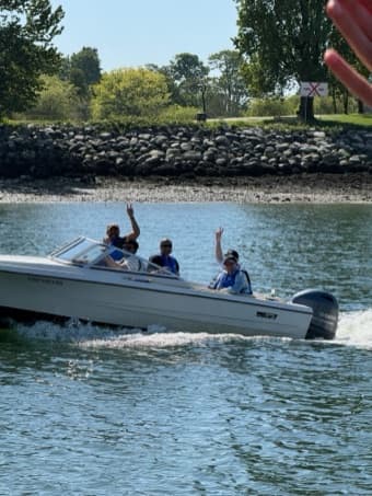 Durable teammates riding a speedboat along a rocky shoreline